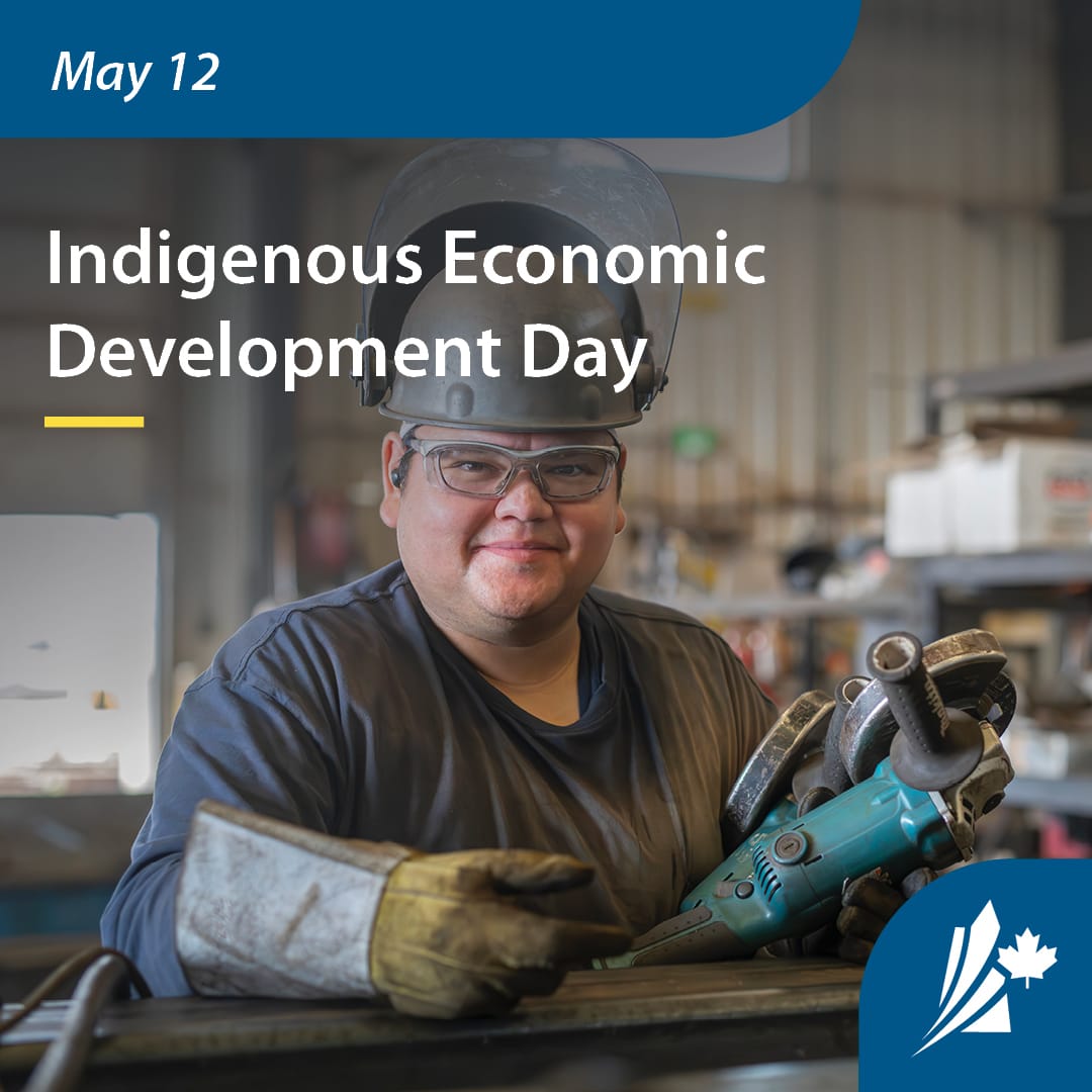 A smiling man wearing safety equipment holding a grinder. The text at the top reads "Indigenous Economic Development Day"