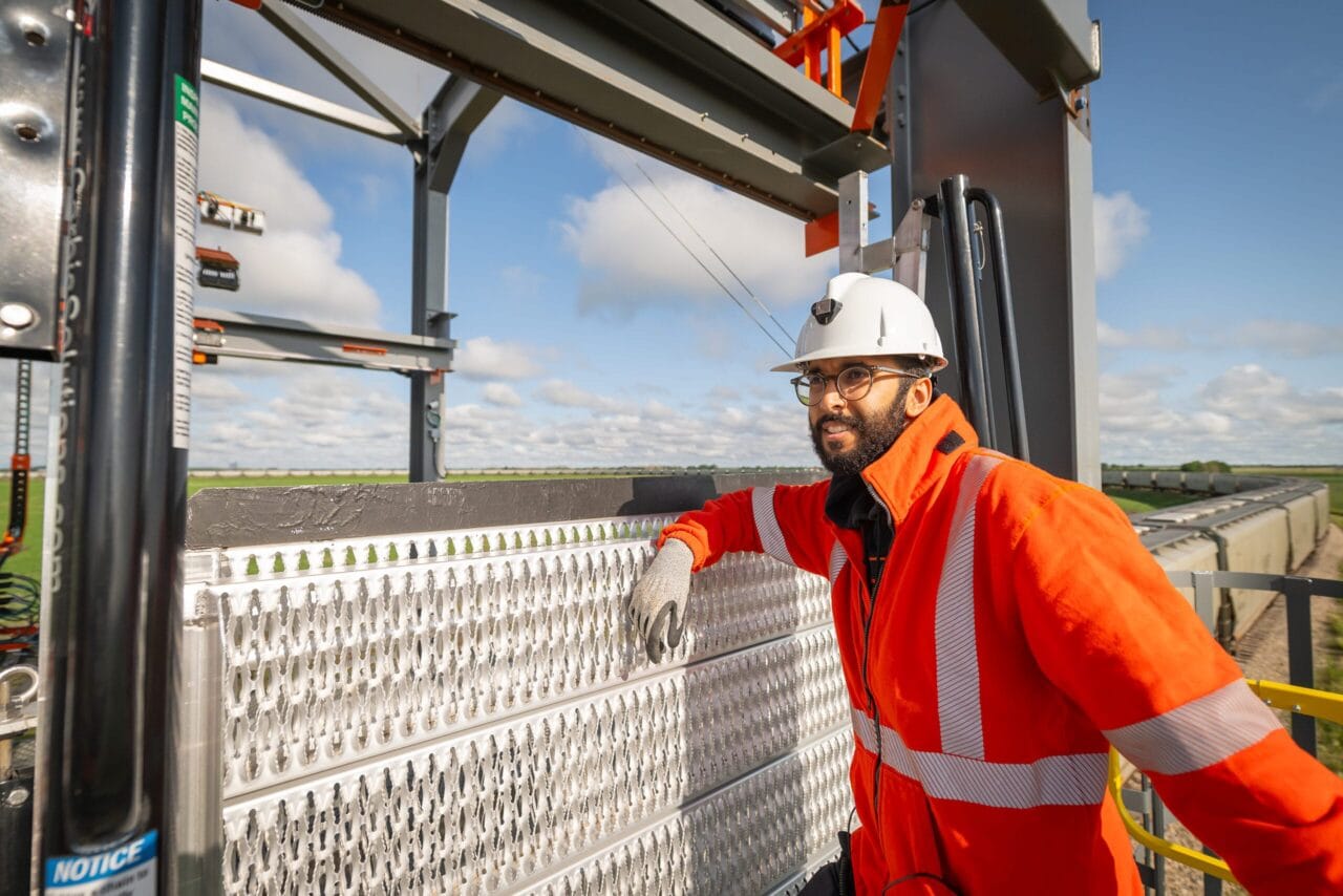 A worker operating on a rail line using Rayhawk technology to load rail cars, representing innovation and efficiency in Saskatchewan’s transportation sector.