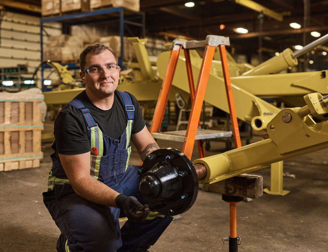 Image shows a worker on a shop floor assembling a manufactured product.