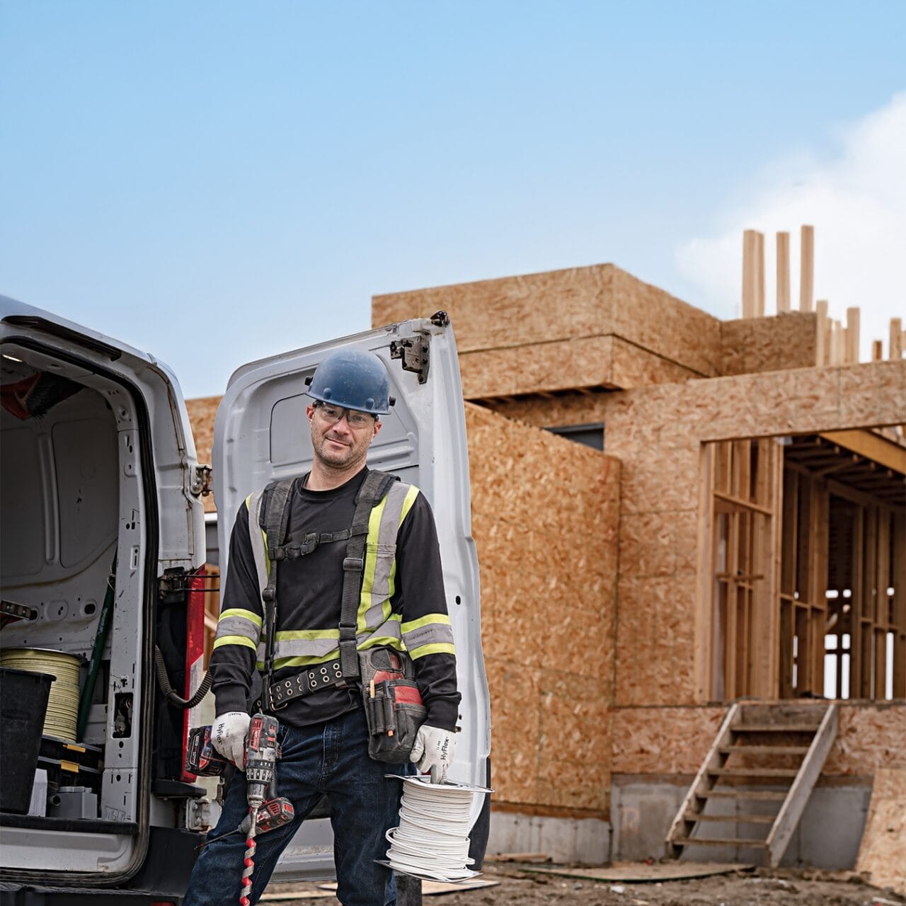 Construction worker standing in front of a partially built house, representing Saskatchewan’s building construction sector,