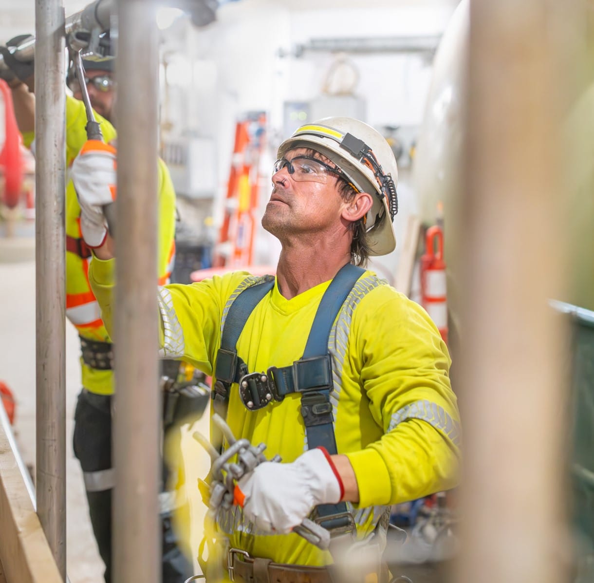 Construction worker installing scaffolding at an active Saskatchewan job site, representing Saskatchewan's construction industry.