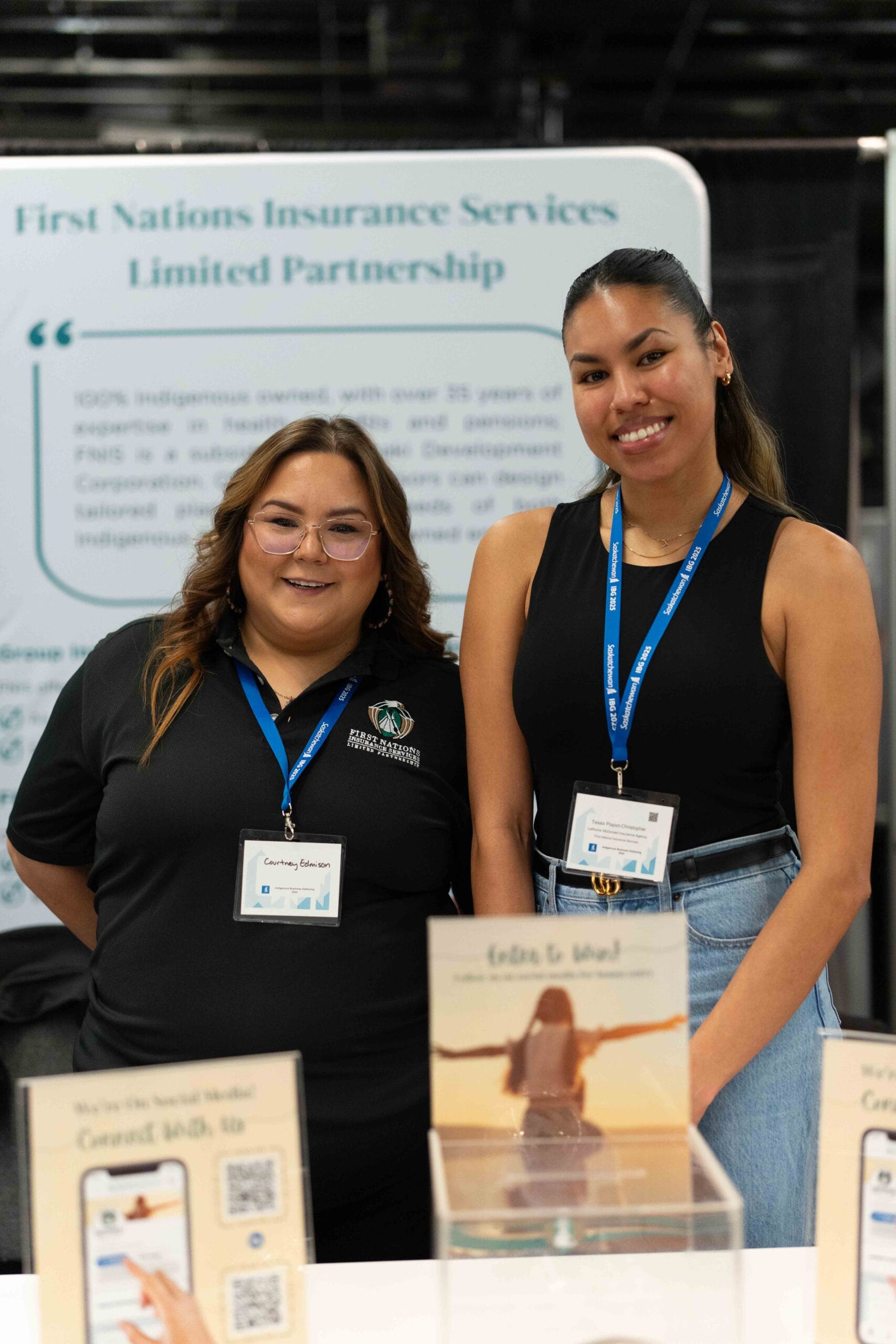 Two Indigenous women work at a tradeshow booth at the Indigenous Business Gathering.
