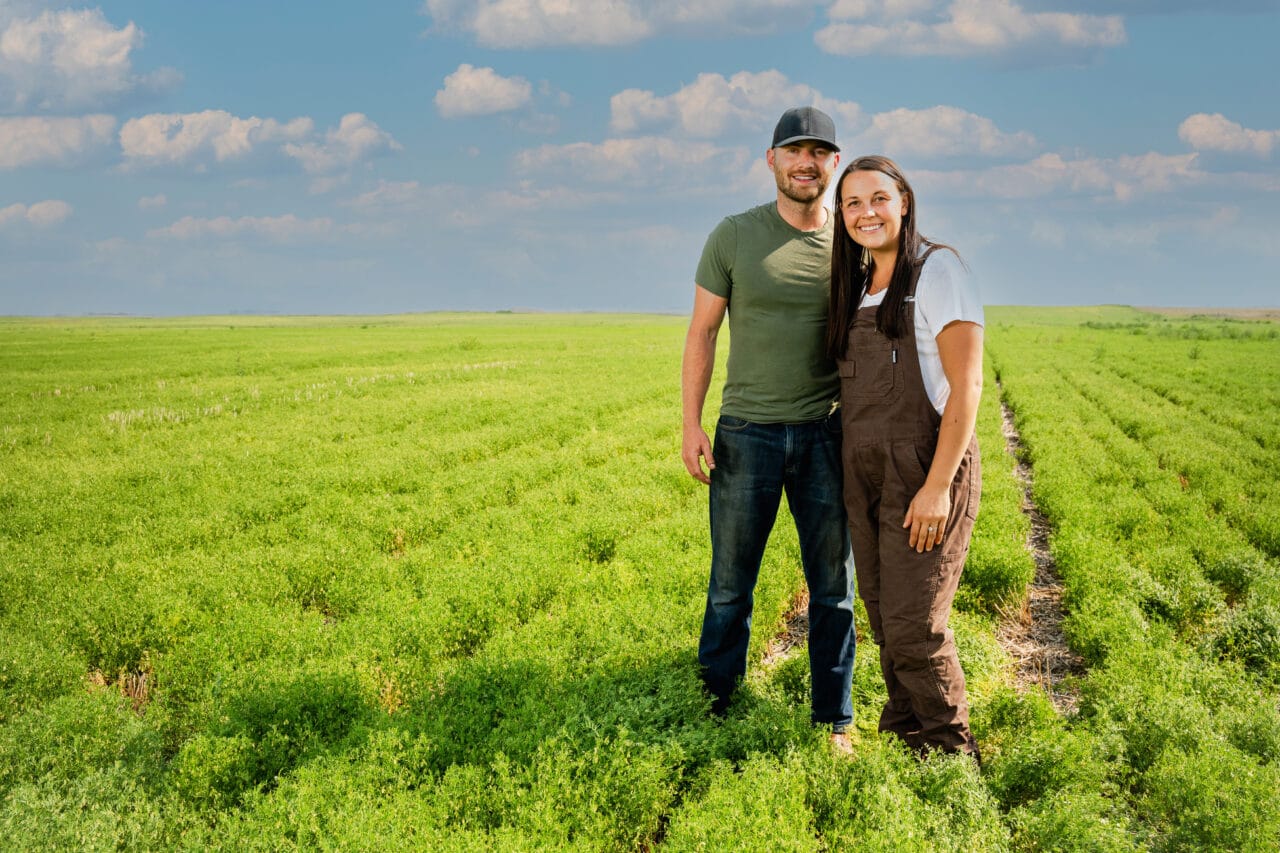 Two farmers stand in a field, representing Saskatchewan’s agricultural sector and economic growth.